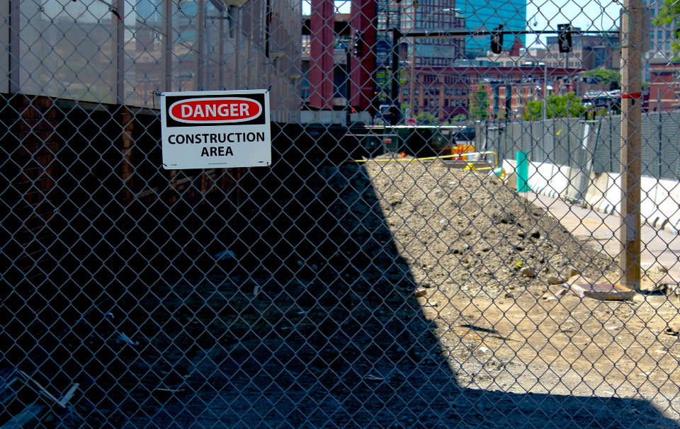 Construction site fenced off behind a DANGER warning sign