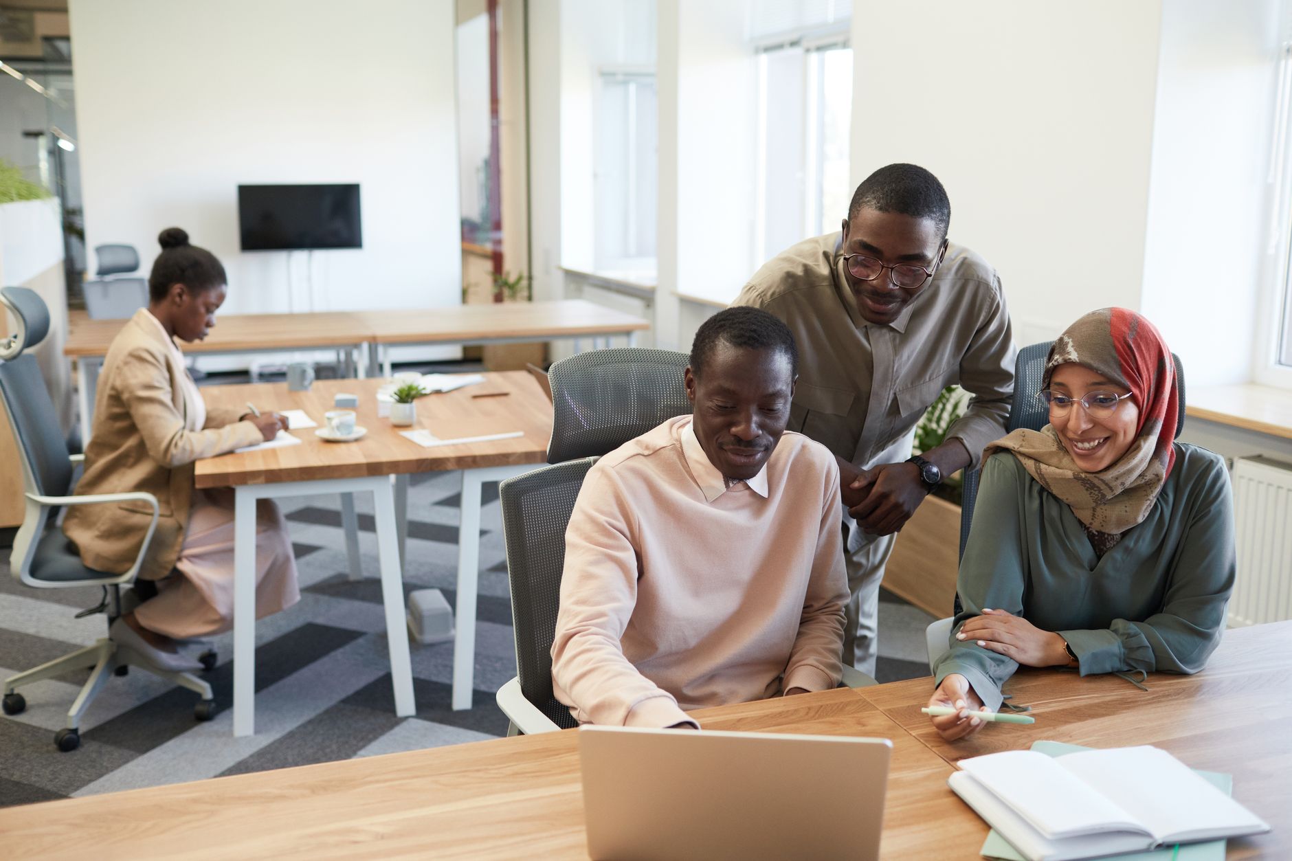 Colleagues working together on a laptop in an office