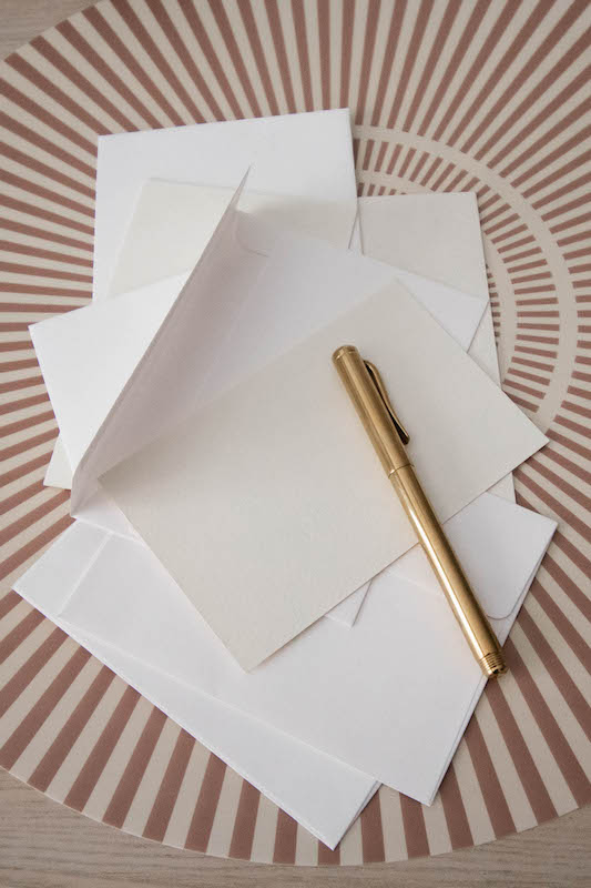 how to implement a quiz funnel in your business (gold pen on a stack of blank paper)